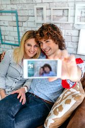 Top view of couple taking selfie on a sofa