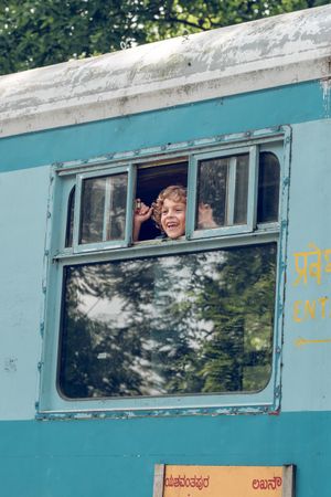 Excited boy riding train and looking out window