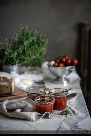 Fresh bread on napkin near tomatoes jam