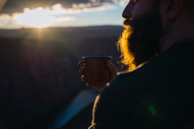 Man drinking near canyon
