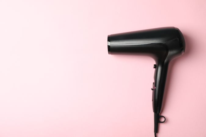 hair dryer on pink background, space for text