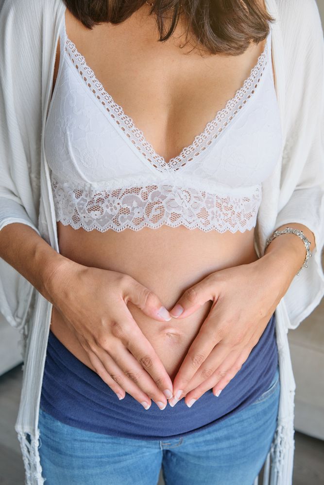 Crop pregnant woman touching belly
