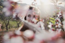 Young happy woman between trees in garden