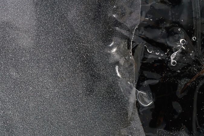 Fragment of thin ice on dark frozen river
