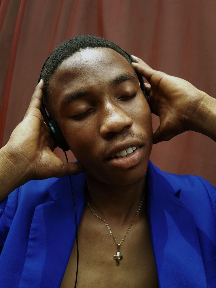 Close-up of man wearing headset and cross chain