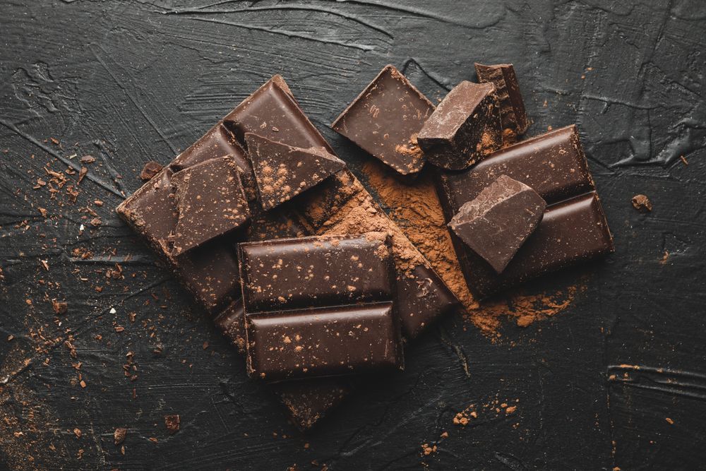 Tasty chocolate and powder on blank background
