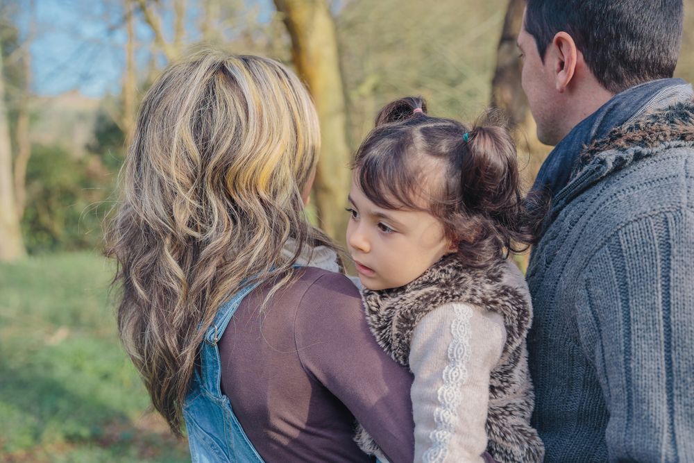 Back of parents with small girl looking out to forest
