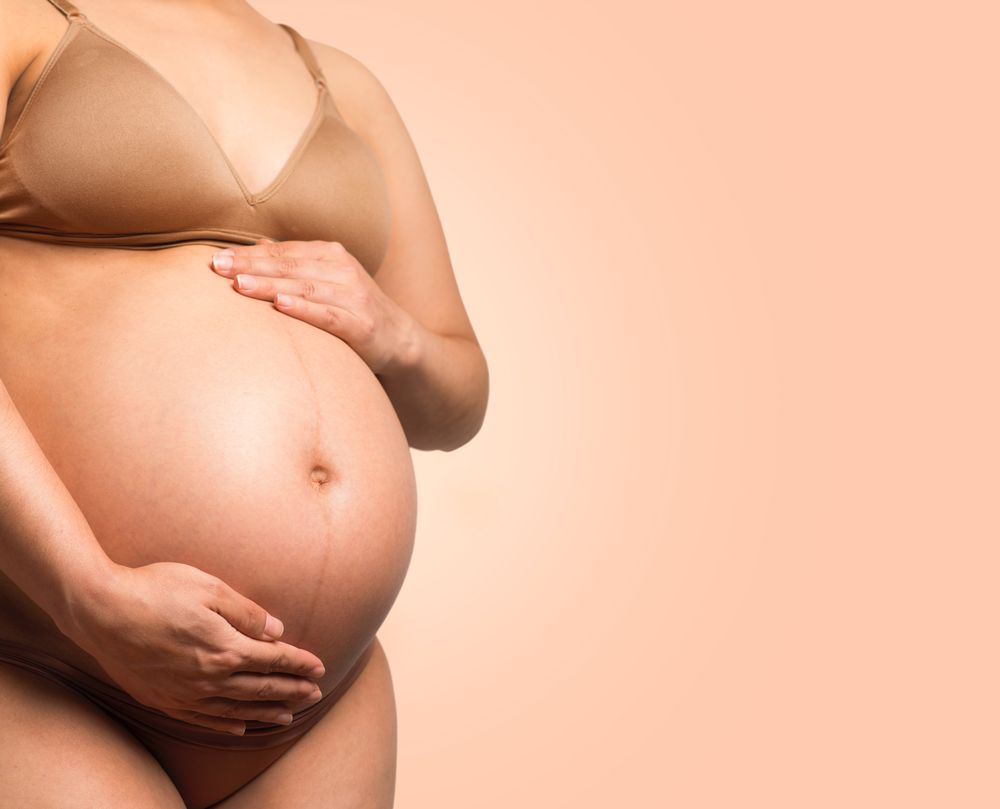 Pregnant woman in brown brassiere and panty