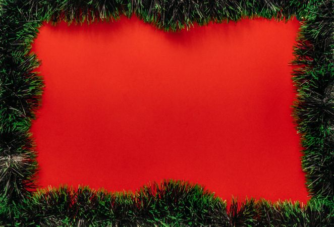 Christmas fir garland frame on red background