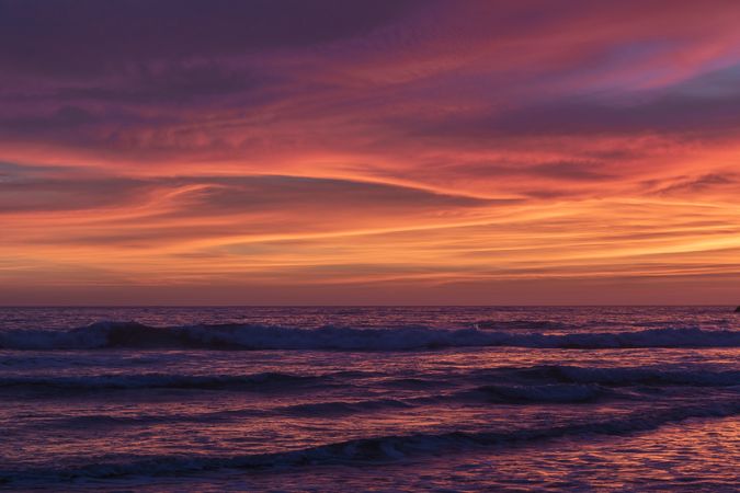 Waves in the Pacific Ocean under a colorful bright sunset