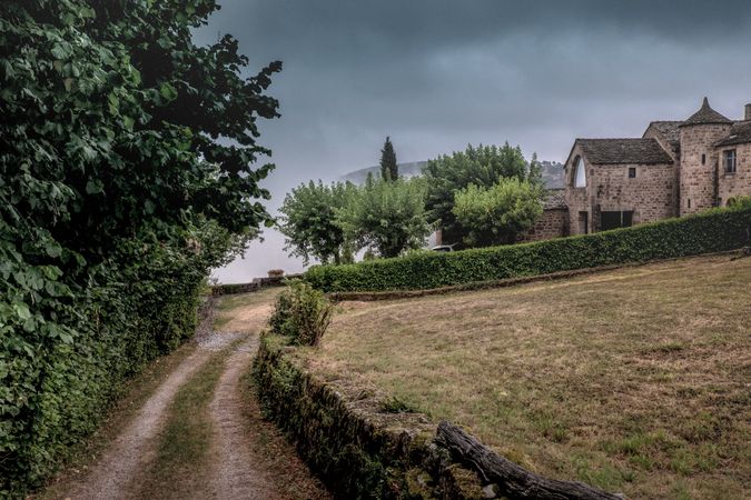 Path next to field in French village on overcast day