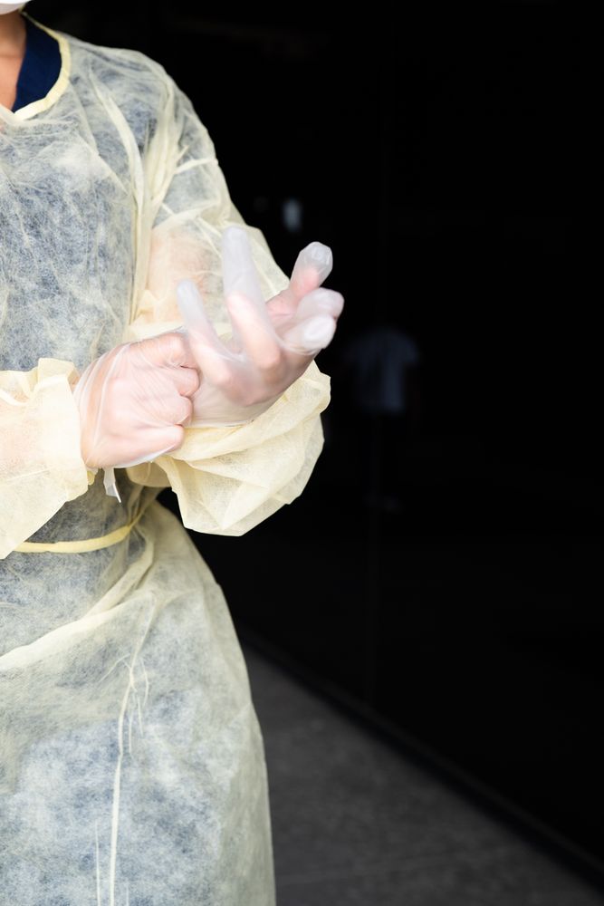 Cropped shot of nurse putting on disposable gloves