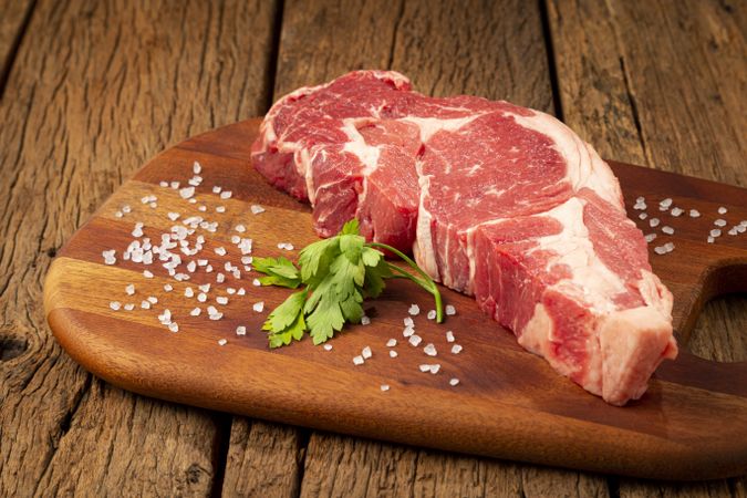 Raw ancho meat ready to roast on a wooden cutting board.