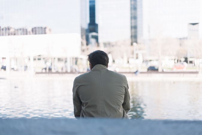 Man sitting looking out at peaceful river