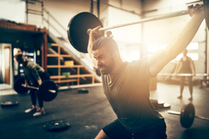 Healthy man performing a snatch with a barbell