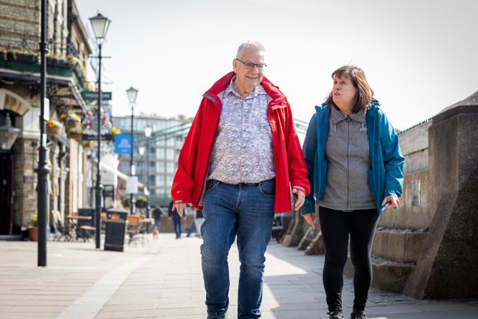 Older man and woman walking together on Thames path