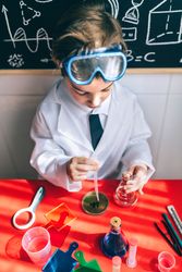 Serious kid playing with chemical liquids