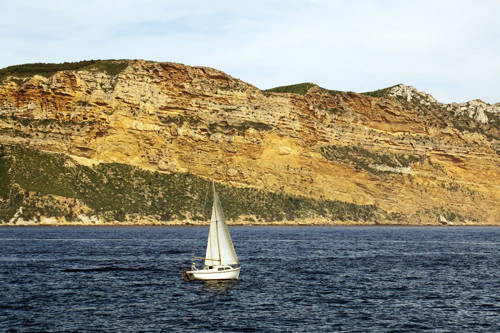 sailboat in sea and beautiful rocks