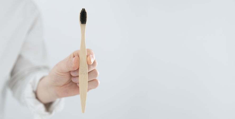 Man holding bamboo toothbrush