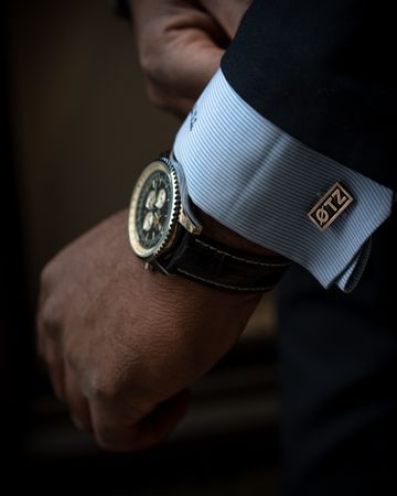Cropped image of man's hand with gold round analog watch