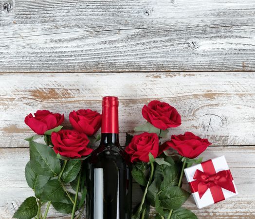 Valentine’s Day celebration with red wine and gifts in bottom of rustic wooden planks