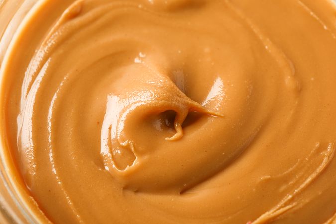 Peanut butter as background, space for text and closeup. A traditional product of American cuisine