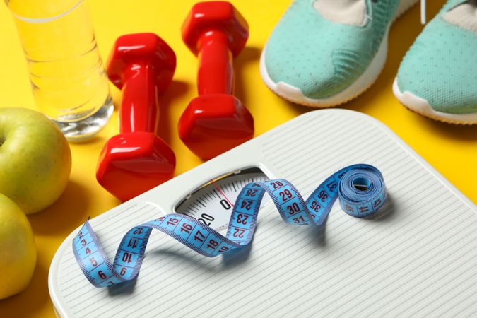 Weight loss or healthy lifestyle accessories on yellow background