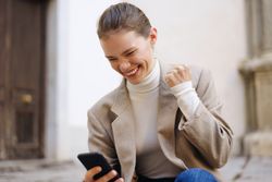 Joyful Moment A Young Woman Celebrating with Her Smartphone in a Cheerful Atmosphere