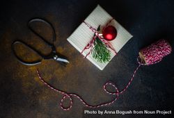 Top view of single Christmas gift with red string and scissors 0ykjn4