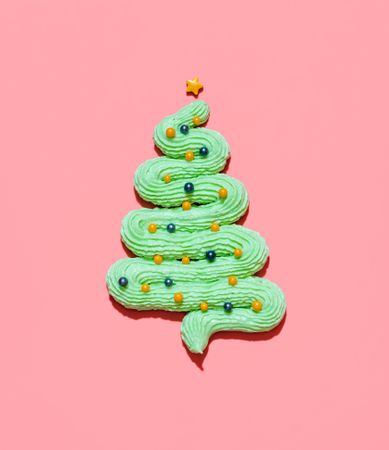 Christmas tree made from buttercream frosting isolated on a pink background