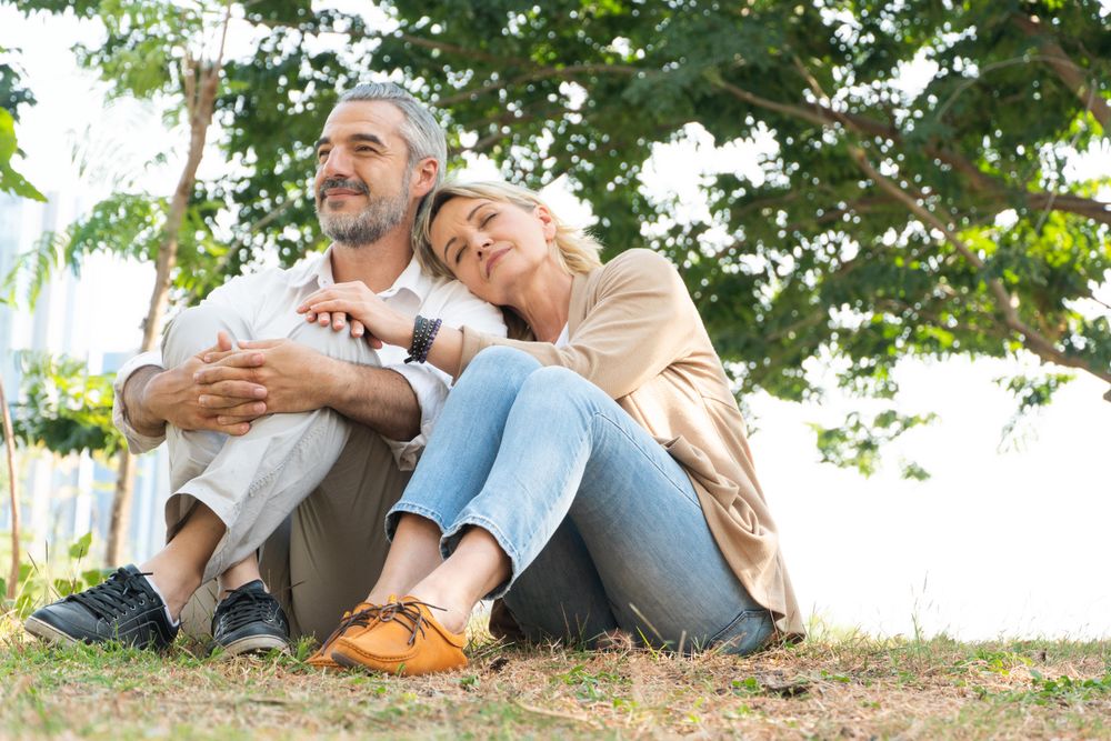 Older couple sitting on grass together at park