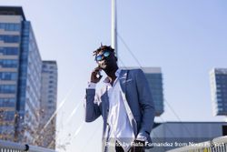 Black man in elegant suit standing in city talking on phone on a sunny day 5Q23qg