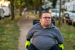 Portrait of happy man sitting in wheelchair in park path bGeDB5