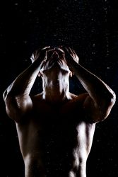 Muscular male under rain