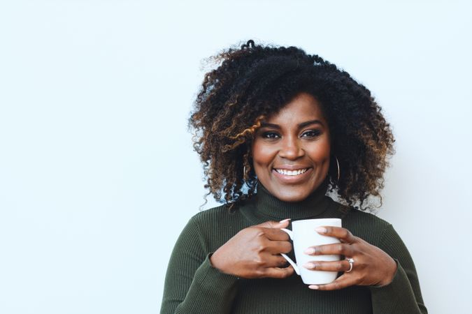 Content Black woman holding a cup of coffee