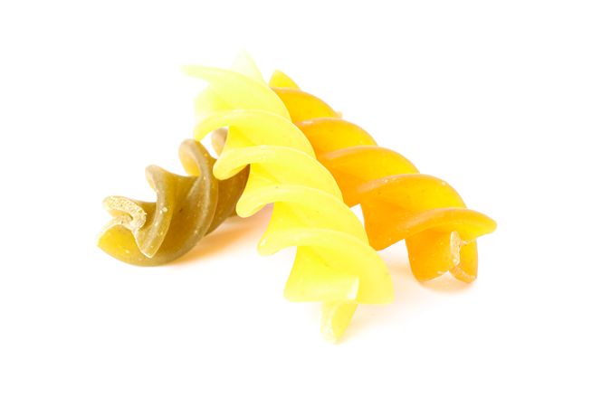 Pasta isolated on light background, closeup. Dry raw whole pasta