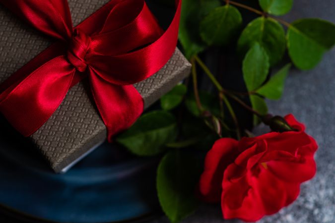 Table setting with red rose and gift