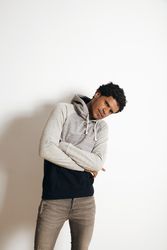 Man posing with arms crossed looking curiously at camera
