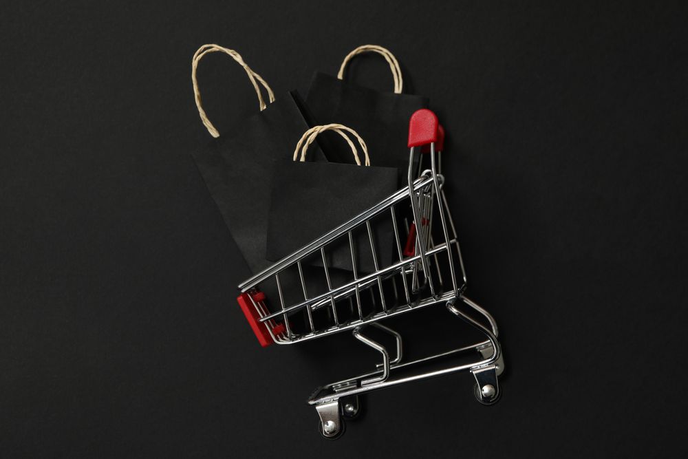 Shop trolley with paper bags on dark background