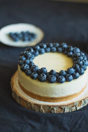 Homemade blueberry cheesecake on wood pedestal