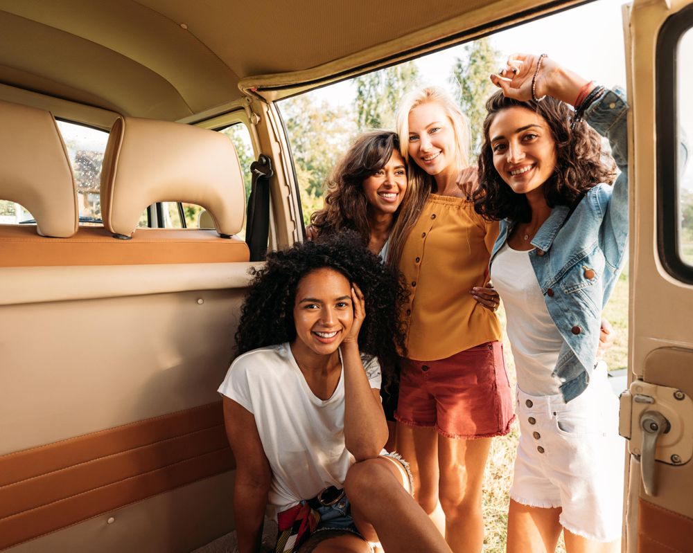 Friends posing in an open van door