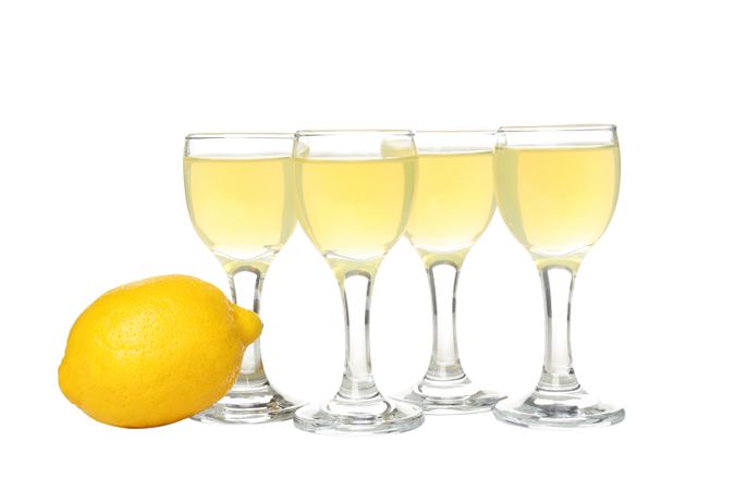 Lemon and cocktail glasses with limoncello, isolated on light background