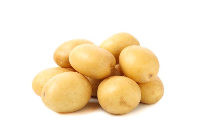 Side view of pile of whole potatoes in bright room