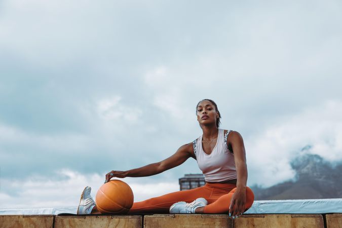 Woman in fitness wear with exercise ball exercising outdoors