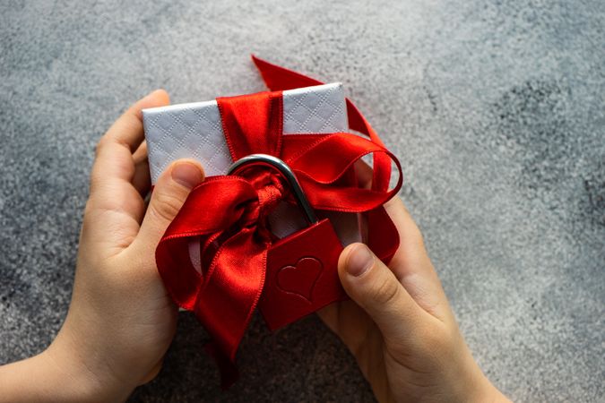 Person holding present with red padlock