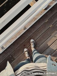 Cropped image of person's feet standing on wooden bridge 5rKxM4