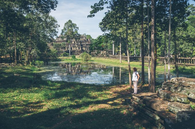 Female traveler in garden near temple