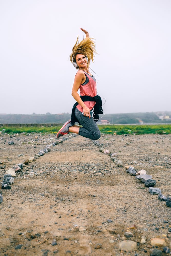 Young sportswoman jumping on the road