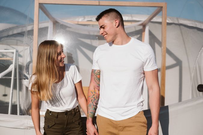 Affectionate couple looking at each other near bubble hotel