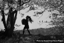 Grayscale photo of young girl standing under cherry blossom tree 5QXXN0